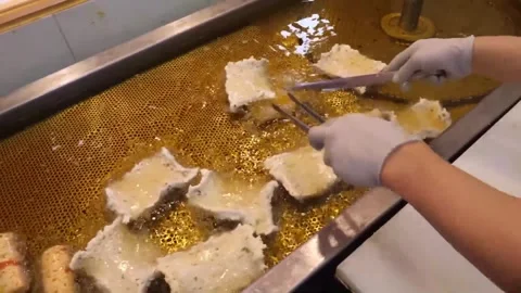 Worker making traditional Korean fish cake eomuk in deep fryer at a street food Stock Footage 337375027
