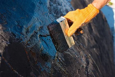 Worker making waterproofing. Stock Photos
