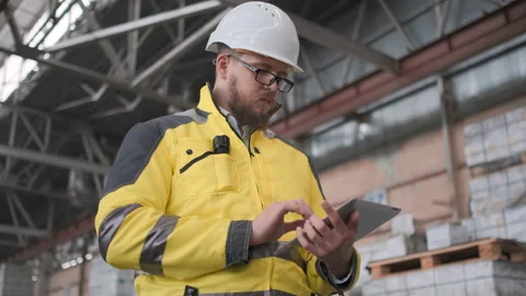 Worker male warehouse worker engineer man in a helmet working on the Stock Footage 114476990