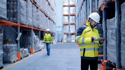 Worker male warehouse worker engineer man in a helmet working on the Stock Footage 128646538