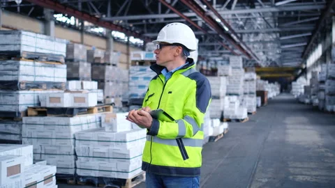 Worker male warehouse worker engineer man in a helmet working on the Stock Footage 157902688