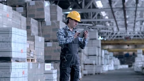 Worker male warehouse worker engineer man in a helmet working on the Stock Footage 172167540