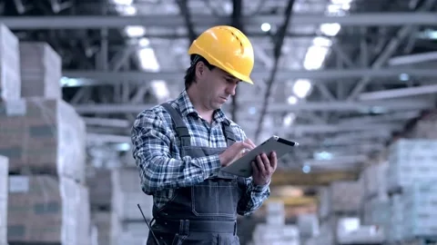 Worker male warehouse worker engineer man in a helmet working on the Stock Footage 172167572