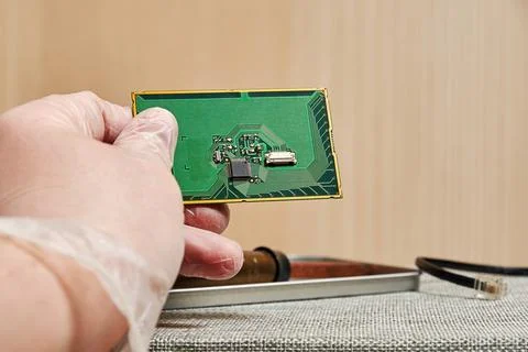 Worker man analyzing on a PCB with a chip in the laboratory Stock Photos