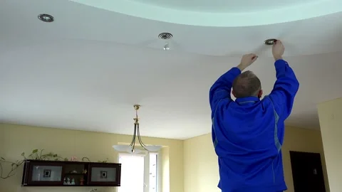 Worker man change LED light bulb in ceiling in client room. 4K Video stock 132343047