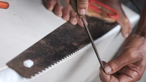 A Worker man Doing Sharpening Tool of His Old Rusty Saw Tooth in Manual Process Stock Footage 219050003