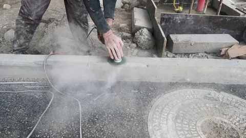 Worker man with grinding machine repairs curb near sidewalk Stock Footage 309964327