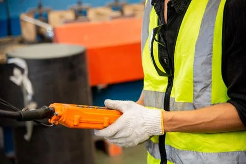 Worker man hand push remote control switch for overhead crane in factory Stock Photos
