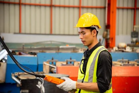 Worker man hand push remote control switch for overhead crane in factory Stock Photos