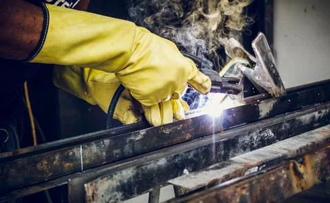 Worker man hands with gloves welding metal in workshop Stock Photos