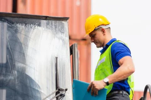 Worker man in hard hat standing on container stackers control loading containers Fotos de archivo