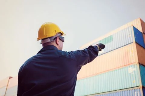 Worker man in hardhat point to the sky, Foreman control loading containers box 库存照片