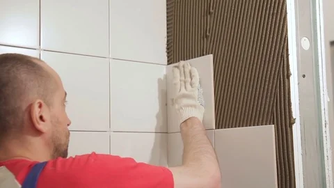 Worker man put plate on wall repairing in bathroom indoors Video stock 79334178