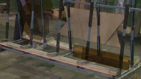 Worker man putting rhombus form sheet of glass on stand Video stock 82402375