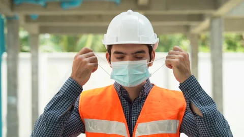 Worker man take off protective face mask End of Coronavirus or Covid-19 pande Stock Footage 147331642