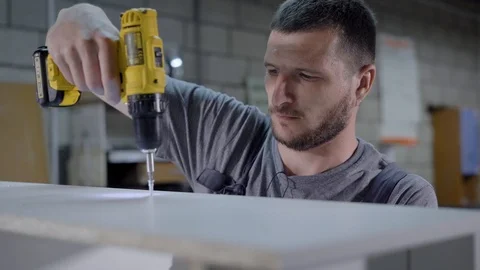 Worker man using drill for wooden panel in factory white Stock Footage 92130328
