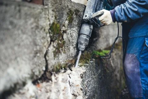 Worker man using a jackhammer to drill into wall. professional worker Stock Photos