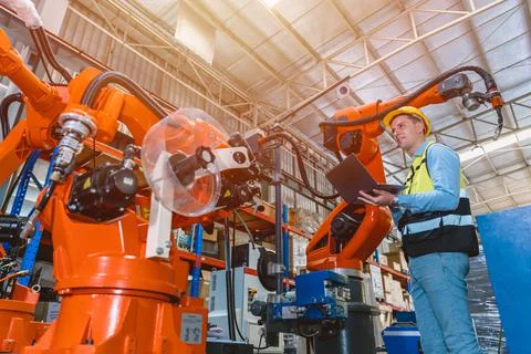 Worker man working with robot arm automate welding machine in modern metal fa 스톡 사진