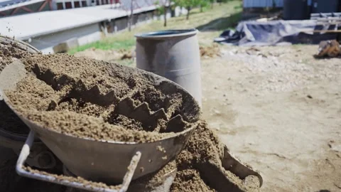 Worker manual loading sand in construction site concrete mixer, slow motion Stock Footage 303181453