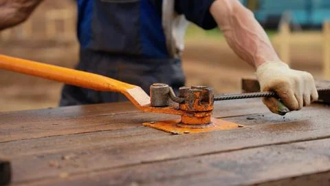 Worker manually bending rebar for concrete construction Stock Photos