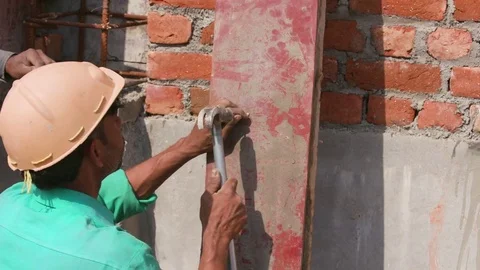 Worker manually drilling a hole on the wooden plank with a nail and hammer Stock Footage 77447476