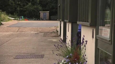 Worker Manually Pushing Utility Trailer into Workshop Stock Footage 345750841