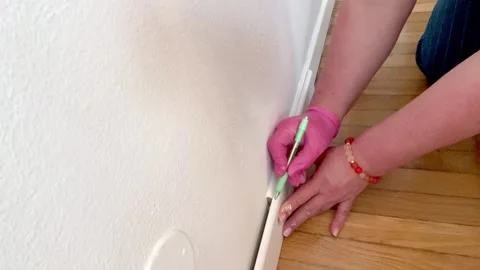 Worker marking baseboard molding with pencil before cutting . Stock Footage 332741890