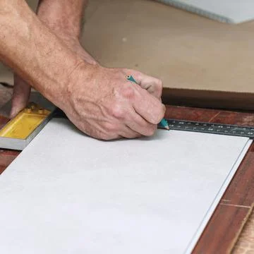 The worker marks the plastic panel with a pencil and tape measure or ruler Stock-Fotos