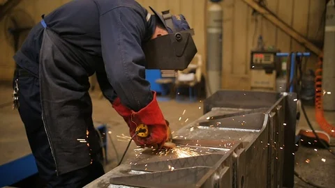 Worker in mask use angle grinderon metal construction metal. Sparks slowly turns Video stock 72697577