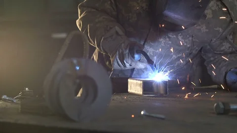 Worker in a mask welding a rectangular metallic tube with plazma sparkles 스톡 동영상 105448958