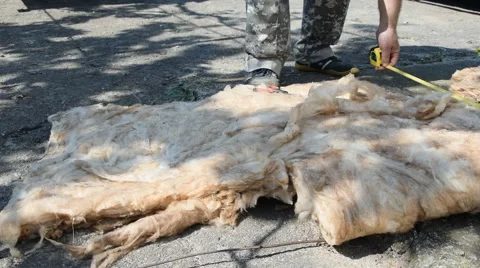 Worker measures and cuts rockwool for house insulation. Close-up Stock Footage 64733986