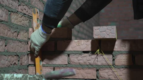 Worker measures brickwork with level at construction site Stock Footage 313831465