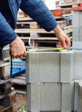 Worker measures cement building blocks on the  warehouse Stock Photos