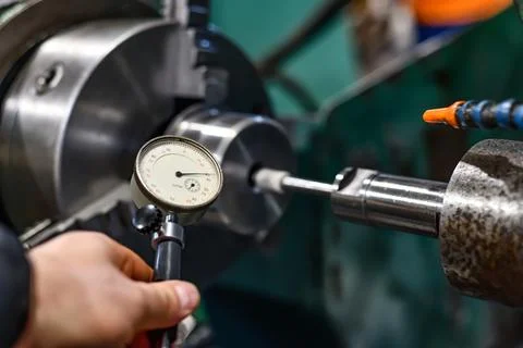 The worker measures the ground hole with an internal gage. Stock Photos