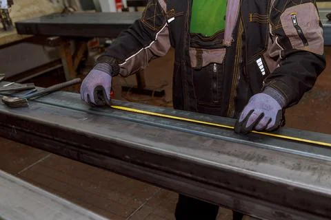 Worker measures markings on a metal surface for drilling holes. Marking tools Stock Photos