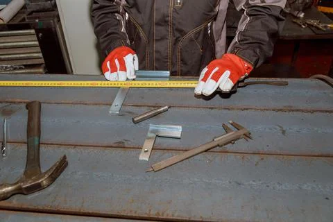 Worker measures markings on a metal surface for drilling holes. Marking tools Stock Photos