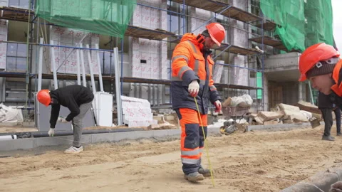 Worker measures sandy layer height using measuring tape Stock Footage 310245600