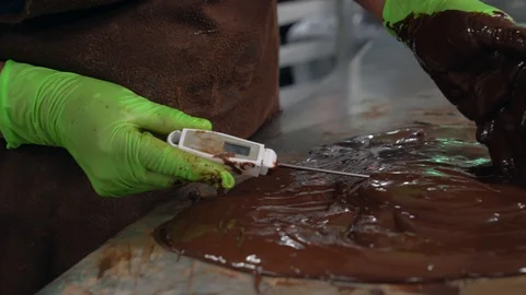 Worker measures temperature of chocolate at chocolate factory Stock Footage 108402144