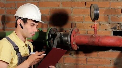 The worker measures the temperature of the heating pipe with a laser pyrometer Stock Footage 77125847
