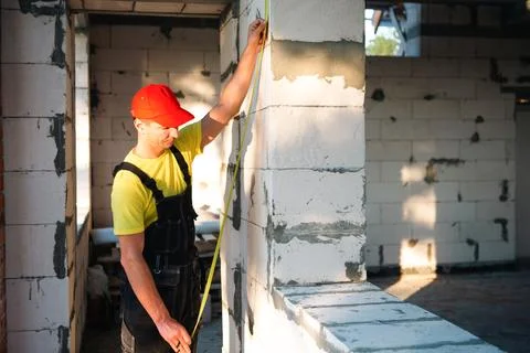 Worker measures window height and wall for installation, interior remodelin.. Stock Photos