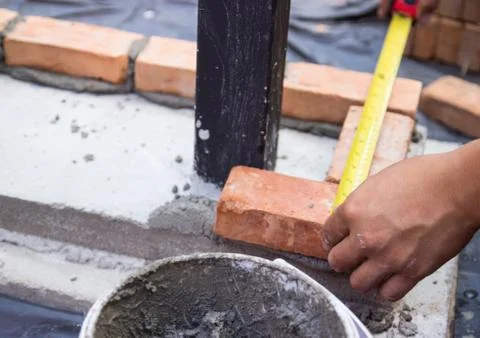 The worker is measuring the brick Stock Photos