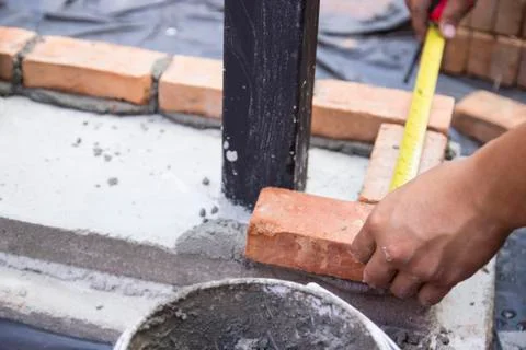 The worker is measuring the brick Stock-Fotos