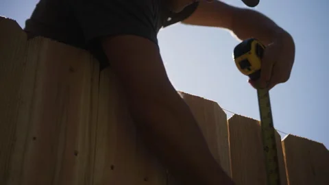 Worker Measuring Cedar Fence Pickets with String Line in Slow Motion Stock Footage 315928357
