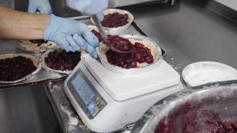 Worker Measuring Cherry Pie Filling On Scale. Stock Footage 321691783
