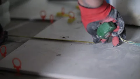 Worker measuring floor tiles during installation Stock Footage 320786172