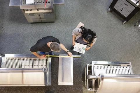 Worker measuring grill for customer in barbeque store Stock Photos