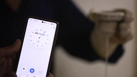 Worker is measuring slurry temperature and thickness in testing app Stock Footage 306365356