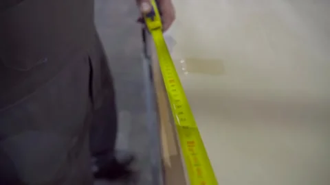 Worker with measuring tape in hand. The builder is taking a measurement Stock Footage 293967526