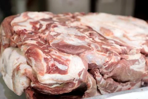 A worker at the meat processing factory, prepares sausages at the work table Stock Photos