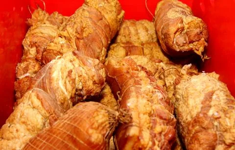 A worker at the meat processing factory, prepares sausages at the work table Stock Photos